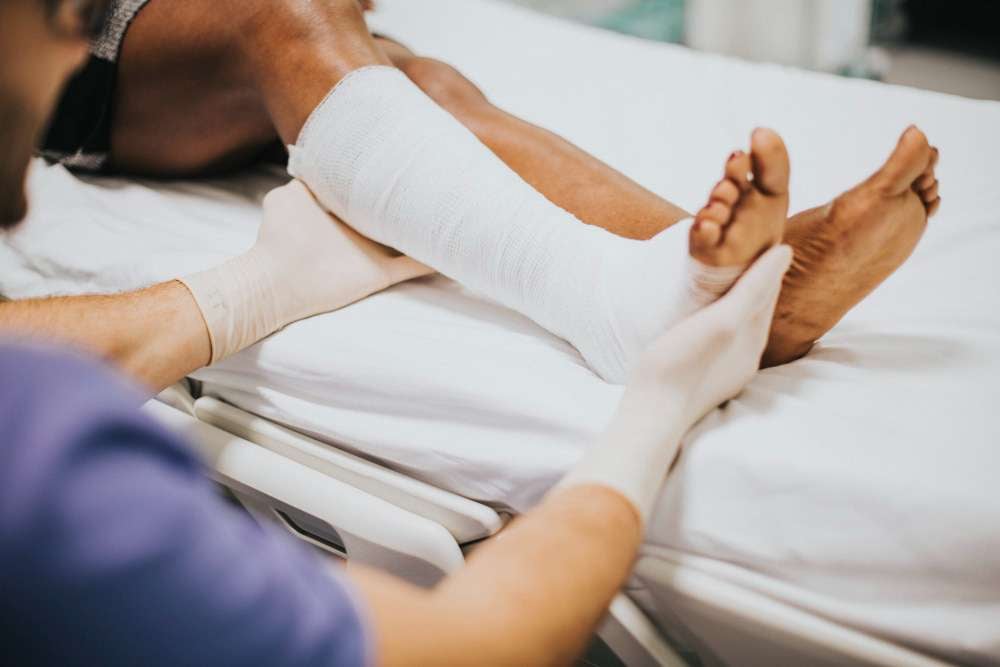 a person white bandage on his feet due to personal injury